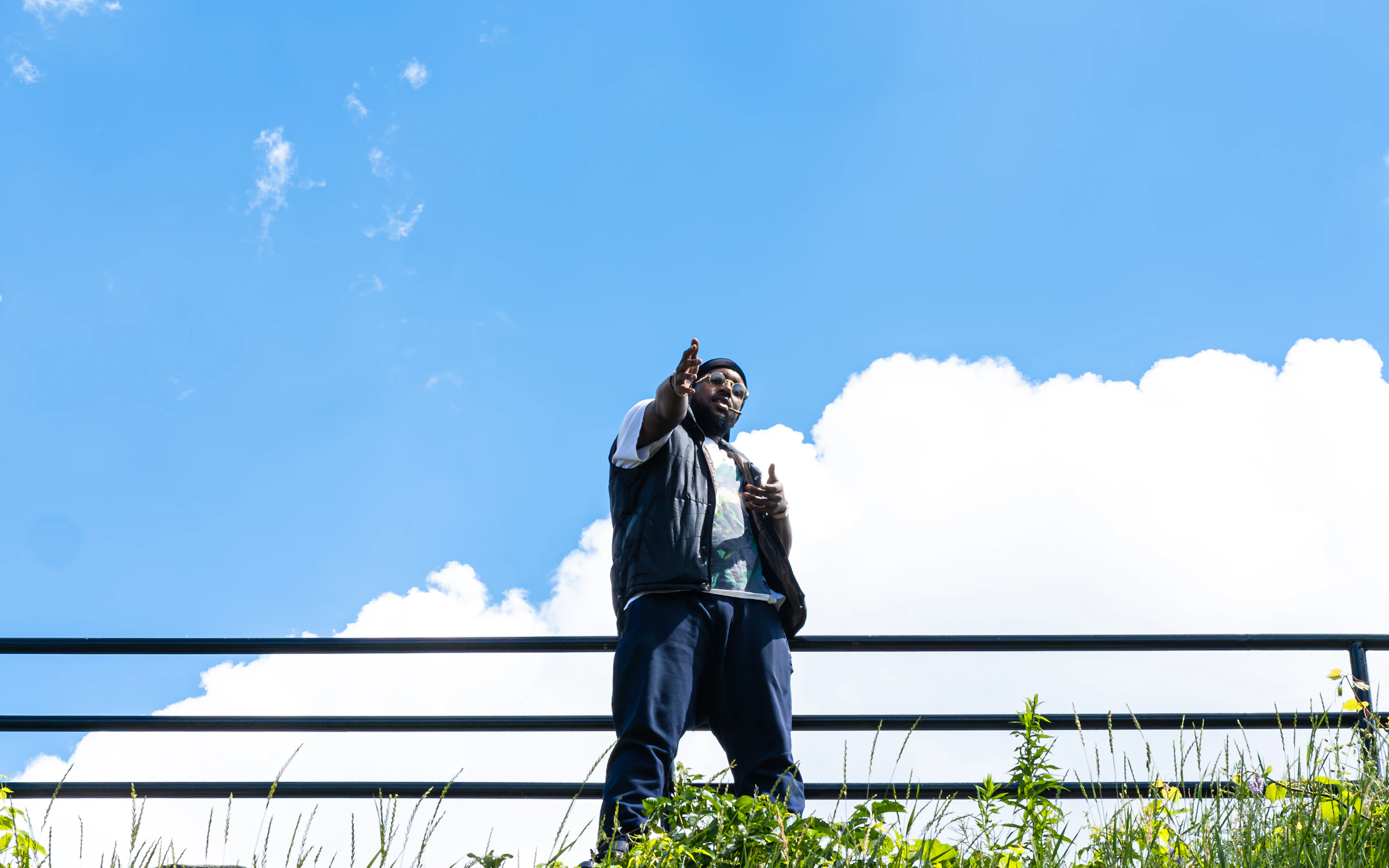 A man on a rooftop against a wide blue sky